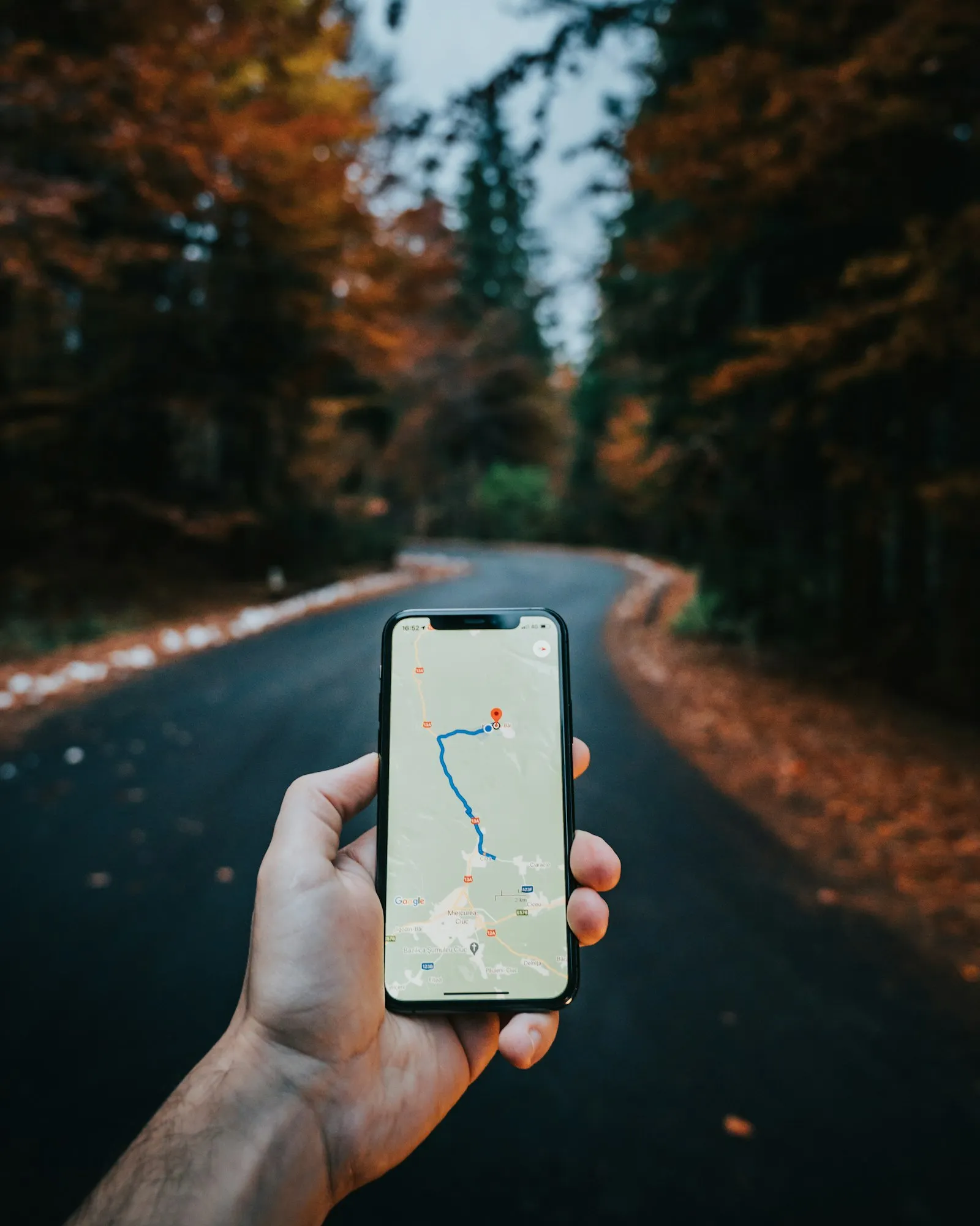 Traveler holding a smartphone with a European city street in the background